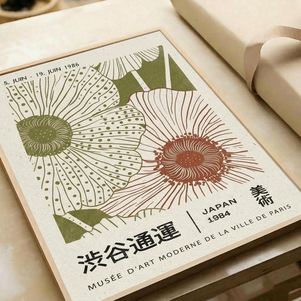 Two stylized sunflowers with radiating petals in olive green and terracotta colors on cream paper. Japanese and French text indicates this is museum exhibition artwork from 1984. The vintage-style print lies flat on white wrapping paper with a beige ribbon nearby, showing fine line work and dotted petal details in an Art Nouveau-inspired botanical design.