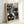 May include: Framed vintage poster with black and white polka-dotted cat faces in various sizes against cream background. Features Japanese text including "JAPAN WEEK," "1984," and "TOKYO." Light wood frame displayed leaning against white wall on white surface, showing artistic exhibition poster design with playful feline motifs created from dotted patterns.