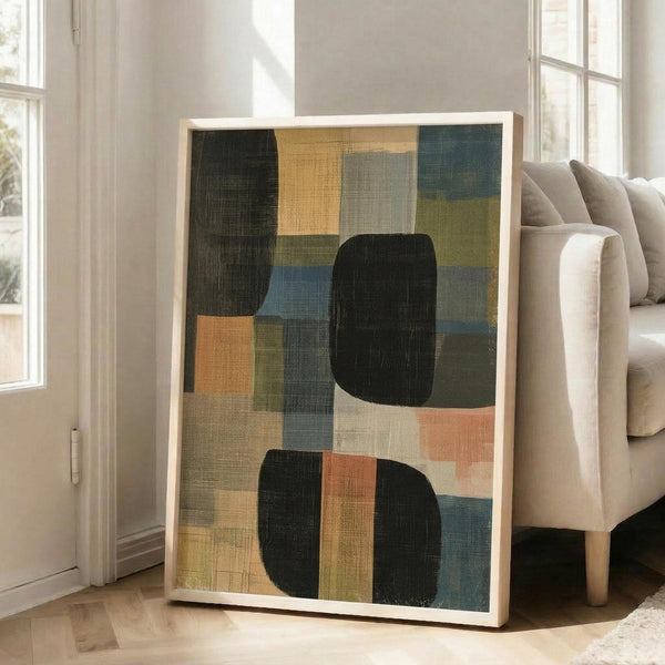 May include: Abstract geometric artwork in light wood frame leaning against white wall next to beige sofa. The poster features overlapping rounded rectangles and squares in muted tones including black, sage green, dusty blue, coral, mustard yellow, and cream with visible brushstroke texture. Natural lighting from windows creates soft shadows on hardwood floors.