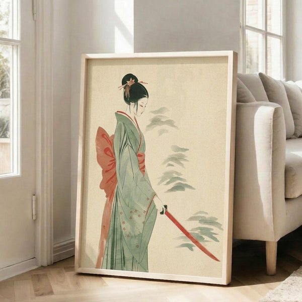 May include: Large framed poster print displayed in bright living room setting, leaning against white wall next to beige sofa. Artwork shows Japanese woman in flowing green kimono with coral-red obi sash, black upswept hair with ornamental pin, holding red katana sword. Delicate watercolor style with soft pine branches in background on cream paper. Natural wood frame, approximately 2-3 feet tall, positioned on light hardwood floor near large windows.