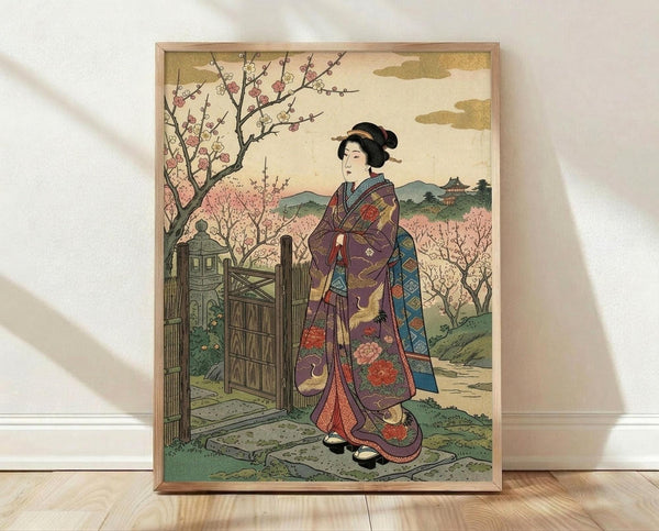 May include: Framed Japanese woodblock print showing a woman in elaborate purple and blue kimono with floral patterns standing beside a wooden gate. Cherry blossom trees bloom in pink and white behind her, with rolling green hills and traditional architecture in the distance. The artwork has muted earth tones and classic ukiyo-e style, displayed in a light wood frame leaning against a white wall on wooden flooring.