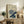May include: Framed vintage Japanese botanical print featuring blue and white chrysanthemum flowers with traditional calligraphy, displayed on rustic wooden sideboard alongside fern plant, ceramic vases, and books in neutral-toned living room setting with cream upholstered furniture
