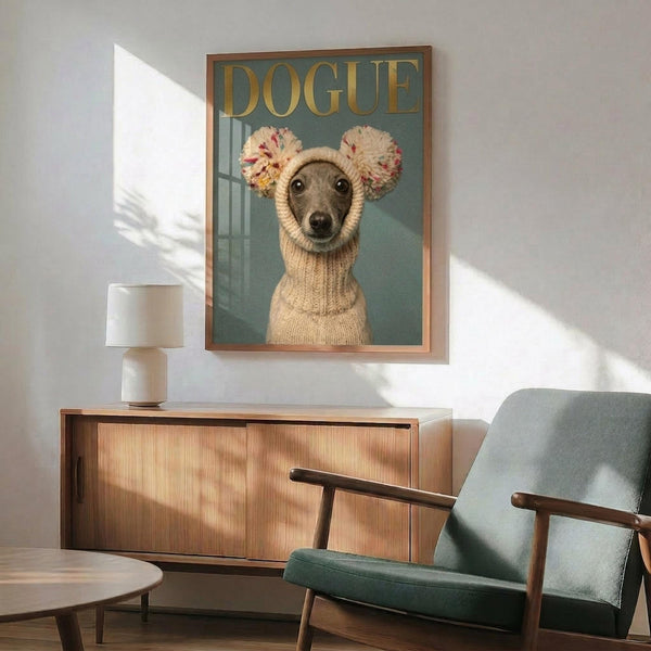 May include: Framed poster featuring an Italian Greyhound wearing a cream knit sweater with colorful pom-pom ears against a teal background, styled like a fashion magazine cover with "DOGUE" text at top. Displayed above a wooden sideboard with table lamp in a modern living room with mint green mid-century armchair.