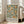 May include: Large framed poster with botanical design featuring orange citrus fruits and green foliage on cream background, displayed against white wall next to beige upholstered sofa in bright living room with tall windows. Natural wood frame complements the vintage-style artwork with exhibition text at bottom.