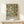 May include: Framed botanical poster featuring orange citrus fruits and green foliage in William Morris decorative style, displayed on light wood shelf against cream wall. Natural wood frame surrounds vintage-inspired textile pattern with "WILLIAM MORRIS" and "CENTENARY EXHIBITION" text at bottom. Small white decorative object sits beside frame.