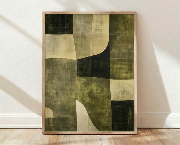 May include: Framed abstract poster with geometric shapes in earth tones of olive green, cream, and dark forest green. The artwork features curved and angular forms with textured, weathered appearance and grid-like patterns. Displayed in light wood frame leaning against white wall on natural hardwood floor with soft window light creating shadows.