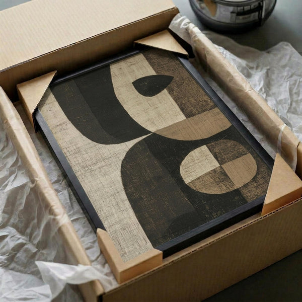 May include: Abstract geometric poster with large curved shapes in dark green, beige, and brown tones displayed in black frame inside cardboard shipping box with protective packaging materials and wooden corner guards visible around frame edges