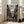 May include: Framed anime poster displayed in bright living room with beige couch and white walls. The colorful artwork shows three sword-wielding characters in traditional Japanese clothing positioned on a historic street scene. Japanese and English text appears at top reading "Samurai Champloo" and "Destiny Lies on the Hip." The poster has a light wood frame and leans against the wall on hardwood flooring near large windows.
