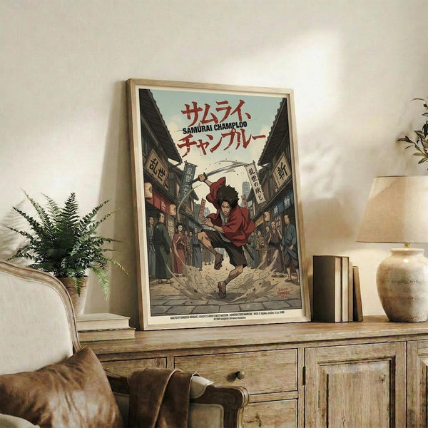 May include: Framed anime poster displaying a samurai character in red clothing wielding a sword on a village street scene with Japanese text at top. Light wood frame sits on rustic wooden sideboard alongside fern plant, books, and ceramic vase. Beige armchair with leather cushions visible in foreground against cream wall.