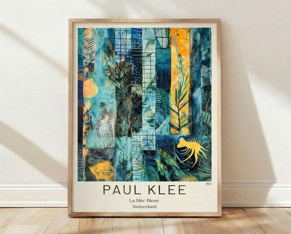 May include: Framed art print leaning against white textured wall on light wood floor. Abstract artwork features layered blue and teal tones with geometric patterns, organic leaf shapes, golden yellow accents, and dark contrasting elements. Mixed media style with grid patterns, dots, and flowing forms suggesting underwater or tropical themes. Natural wood frame with white matting displaying artist attribution text below the image.