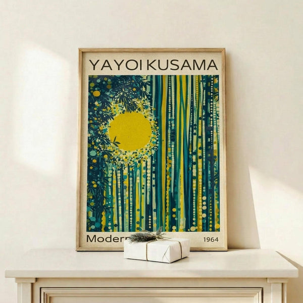 May include: Framed art print with yellow sun and green forest design in modern abstract style, displayed on light wood shelf next to small wrapped gift with feather accent against white wall