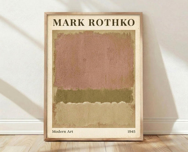 May include: Framed poster print featuring abstract color field artwork with soft horizontal bands in muted pink, olive green, and cream tones. The print has aged, vintage-style coloring and is displayed in a light wood frame against white fabric backdrop on wooden flooring with natural window light casting shadows.