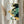 May include: A framed abstract art print with flowing organic shapes in navy blue, emerald green, and golden yellow colors, displayed on a white wall next to dried pampas grass stems. The artwork features Japanese calligraphy characters on the left side and curved, river-like forms that blend and interweave across the composition. The print is mounted in a thin natural wood frame.