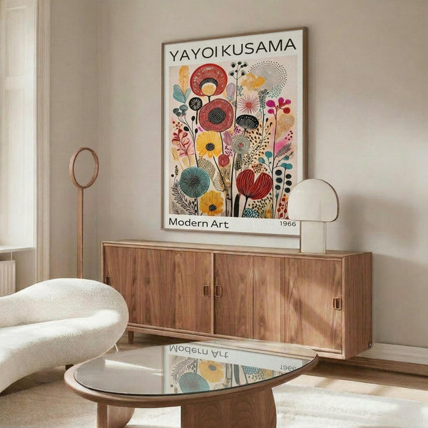 May include: Colorful mid-century modern botanical poster print displayed above wooden credenza in bright living room. White curved chair and glass coffee table in foreground. Artwork features stylized flowers in vibrant reds, yellows, blues and greens with geometric patterns. Natural wood furniture and neutral walls create Scandinavian-inspired interior setting.