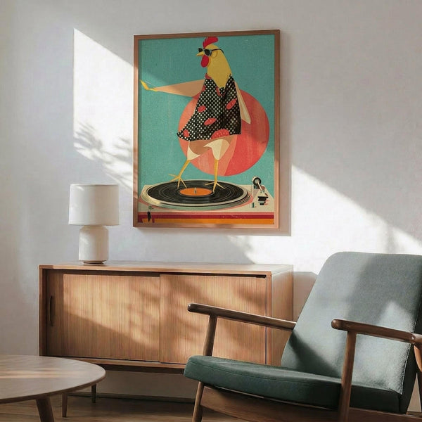 May include: Framed poster showing a stylized rooster with yellow head and red comb wearing a black polka dot dress, standing on a vinyl record turntable against a teal background with coral circle. Displayed above a wooden sideboard with white ceramic lamp in a mid-century modern living room with green upholstered chair.