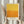 May include: Person holding a framed art print featuring a yellow to orange gradient color field painting with textured brushstrokes, displayed against white curtains with dried pampas grass visible to the left side.