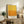 May include: Framed abstract art print with yellow and orange color field design in warm gradient tones, displayed on rustic wooden sideboard alongside fern plant, ceramic vases, and books in neutral-toned living room with cream chair and textured throw blanket.