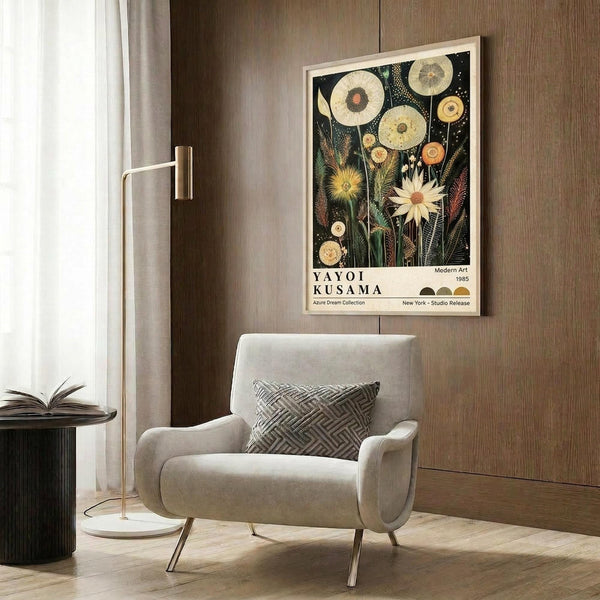 May include: Botanical art poster featuring circular flower and plant specimens in cream, yellow, and orange tones against a dark background, displayed in light wood frame above beige upholstered armchair with geometric patterned pillow, brass floor lamp, and dark round side table with open book in modern living room with wood paneled walls
