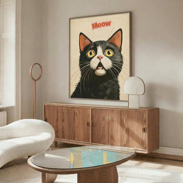 May include: Framed retro-style poster of a black and white tuxedo cat with wide yellow eyes and open mouth saying "Meow" in red text, displayed above a mid-century modern walnut credenza with brass handles. Room features white upholstered swivel chair, brass floor lamp, white table lamp, oval glass coffee table, and neutral walls with natural lighting.