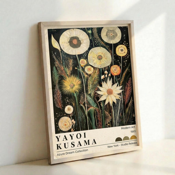 May include: Framed art print leaning against white wall showing botanical illustration with large circular flowers and detailed leaves on dark background. Light wood frame surrounds artwork featuring cream and yellow blooms with intricate centers, tall stems, and scattered dots resembling stars. Text at bottom reads "YAYOI KUSAMA" with "Modern Art 1985" and "Azure Dream Collection" details. Natural lighting creates soft shadows on wall.