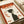 May include: Vintage-style Japanese poster with red border featuring silhouette of person in profile looking upward, surrounded by geometric orange squares and Japanese text. Print shown on white paper with cream-colored tube nearby, displaying retro color palette of red, orange, dark green, and cream with textured, grainy finish.