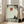 May include: Framed zen artwork showing silhouetted monk meditating under tree with red sun above, displayed in bright living room with beige sofa, wooden floors, and white walls with natural sunlight streaming through windows.