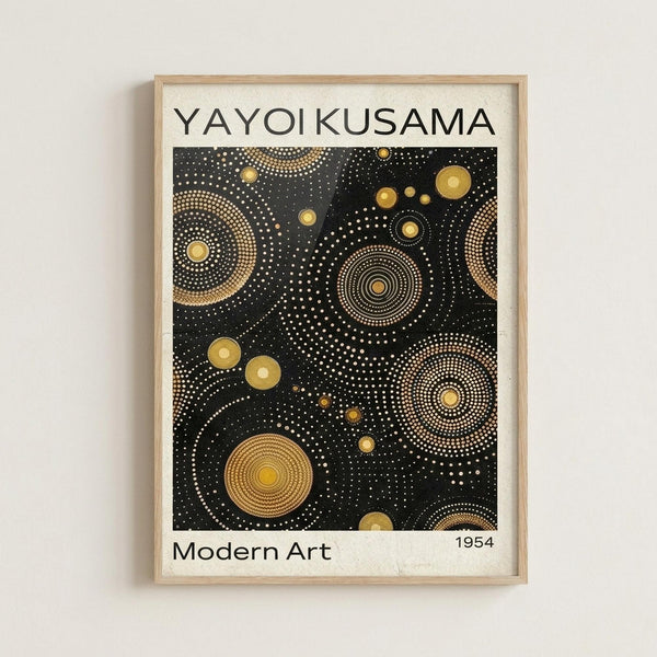 Framed poster with black background featuring golden circular dot patterns in various sizes, resembling celestial or organic forms. White text reads "YAYOI KUSAMA" at top and "Modern Art 1954" at bottom. Light wood frame mounted on white wall in minimalist setting.