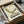 May include: Framed vintage-style poster with green curved chair design and "VISIONS" text, displayed in cardboard shipping box with white tissue paper and wooden dowels, showing unboxing presentation on neutral surface.