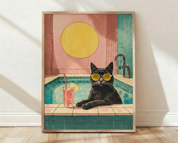 May include: Framed poster print leaning against white wall on light wood floor. Artwork shows black cat wearing round yellow sunglasses sitting poolside with turquoise water, coral-pink drink with striped straw and lemon slice nearby. Large yellow sun in coral-pink sky background. Retro-style illustration with warm coral, teal, and yellow color palette in natural wood frame.