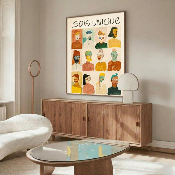 May include: Colorful illustrated poster with twelve diverse portrait illustrations arranged in a grid, featuring people of various ethnicities wearing different clothing and accessories, displayed above a wooden credenza in a modern living room with white curved chair and glass coffee table