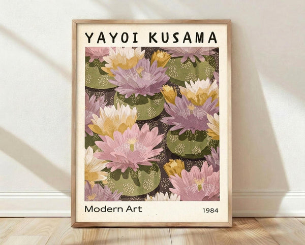 May include: Framed poster print featuring pink and purple lotus flowers with olive green lily pads on dark background, displayed in light wood frame leaning against white wall on wooden floor with soft natural lighting and shadows