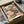 May include: Framed floral art print with pink and yellow lotus flowers on green lily pads against dark background, displayed in black frame inside cardboard shipping box with protective tissue paper and wooden dowel rods