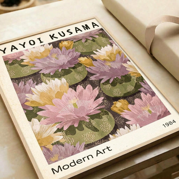May include: Framed art print featuring pink and purple flowers with green leaves on dark background, displayed on light wooden surface next to cream colored ribbon. The vintage-style floral artwork shows soft pastel blooms in an impressionistic pattern with dotted textures throughout the design.