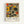 May include: Framed abstract art print in light wood frame hanging on white wall. Artwork features geometric shapes, circles, and organic forms in muted colors including orange, yellow, olive green, and beige arranged in grid-like composition. Text below reads "PAUL KLEE" with "PLAYFUL ABSTRACTION" and "MUSEUM EDITION" in smaller print on cream background.
