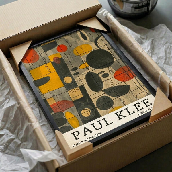 May include: Abstract mid-century modern art print in black frame, packed in cardboard box with protective tissue paper. Features geometric shapes in orange, yellow, green and black with musical instrument motifs. Unboxing scene on white fabric surface with wooden rolling pin nearby.