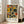 May include: A framed abstract art print leaning against a white wall next to a beige sectional sofa in a bright living room with large windows. The artwork features geometric shapes in yellow, orange, green, and black with playful lines and circles in mid-century modern style. Text reads "PAUL KLEE" and "PLAYFUL ABSTRACTION MUSEUM EDITION" below the colorful composition. Natural light streams across hardwood floors.