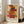 May include: Framed poster featuring abstract geometric composition with overlapping translucent rectangles in warm reds, oranges, yellows and browns on cream background. Text reads "architectural poem" at top and "PAUL KLEE PLAYFUL ABSTRACTION MODERNISM 1879-1940" at bottom. White frame leans against white wall next to beige sofa in bright sunlit room with large windows and hardwood floors.
