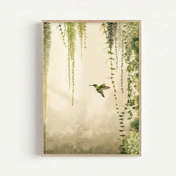 A botanical art print in a light wood frame showing a green hummingbird in flight among hanging ferns and trailing vines. The artwork features various species of drooping foliage including ferns with delicate fronds and cascading greenery against a soft, textured cream and tan background. The composition has a vintage natural history illustration style with detailed botanical elements framing the small bird in the center.