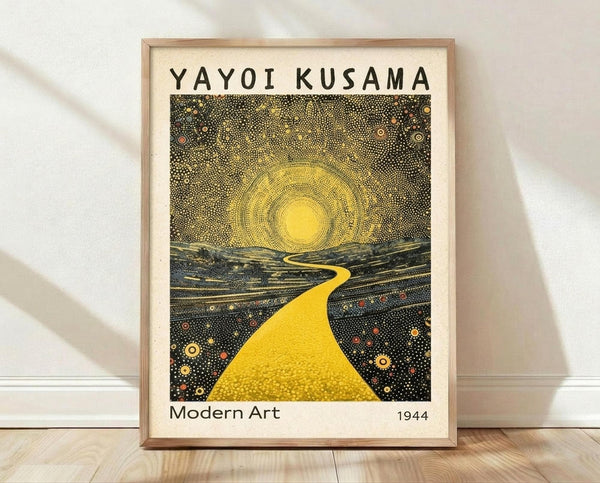 May include: Framed art print leaning against white wall on light wood floor. Print features dotted pattern artwork with bright yellow winding path leading to glowing sun, surrounded by dark landscape with colorful circular elements. Text reads "YAYOI KUSAMA" at top and "Modern Art 1944" at bottom. Natural wood frame, cream colored mat border, soft natural lighting creates gentle shadows on textured white wall.