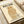 May include: Vintage-style poster featuring a stylized orange and brown owl with intricate geometric patterns, displayed on cream-colored paper. Japanese text at top, English text below reads "International Peace Society" with museum and date information for 1974 Tokyo exhibition. Poster shown flat on white surface with rolled paper tubes nearby.
