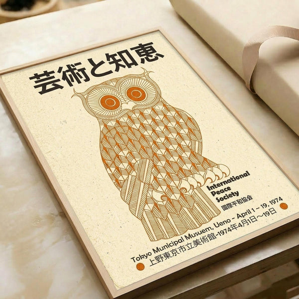 May include: Vintage-style poster featuring a stylized orange and brown owl with intricate geometric patterns, displayed on cream-colored paper. Japanese text at top, English text below reads "International Peace Society" with museum and date information for 1974 Tokyo exhibition. Poster shown flat on white surface with rolled paper tubes nearby.
