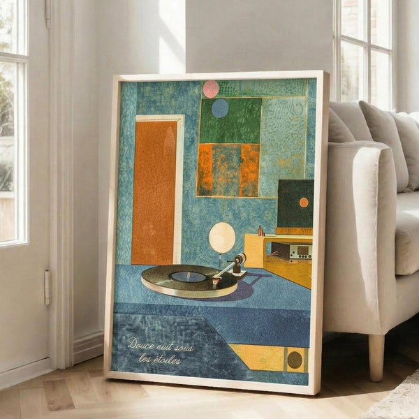 May include: Framed abstract art print featuring a vintage turntable surrounded by geometric shapes in blues, greens, oranges and yellows with French text at bottom, displayed on wooden floor next to beige sofa in bright living room with white walls and windows