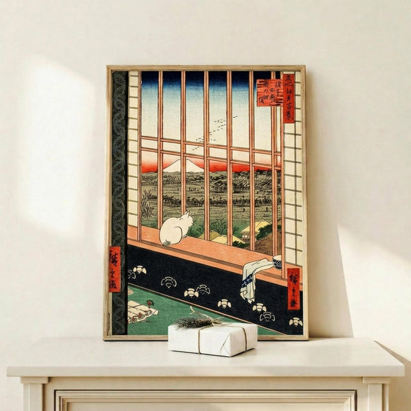 May include: Framed Japanese woodblock print showing interior view through wooden window bars overlooking landscape with Mount Fuji. White cat sits on windowsill beside folded cloth. Traditional tatami room with geometric floor patterns in green and black. Artwork features classic ukiyo-e style with red cartouches containing Japanese text. Small wrapped gift box sits on light wooden shelf below the gold-framed print against white wall.