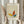 May include: Person holding framed minimalist butterfly artwork in beige tones with colorful geometric wings in yellow, orange, and teal. Frame has cream matting with "PICASSO" and "Uffizi Gallery Collection de Dessins" text. Other hand holds dried pampas grass stems against soft neutral background with flowing curtains.