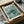 May include: Framed vintage-style poster featuring a detailed green sea turtle swimming among coral and seaweed in muted teal and sage tones, displayed in a cardboard shipping box with protective tissue paper wrapping and wooden frame components visible around the edges.