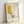 May include: A framed poster print featuring abstract geometric shapes in mustard yellow and earth tones with a stylized coffee cup, displayed in a light wood frame against a white wall. The minimalist artwork shows clean lines and modern artistic elements with text reading "PICASSO" at top and "Centre Pompidou" at bottom, indicating it's a limited edition print numbered 04/50.