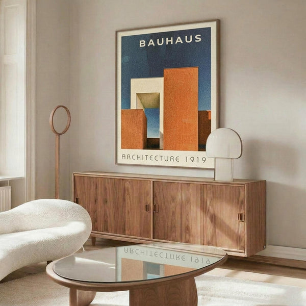 May include: Framed Bauhaus poster with geometric orange and blue shapes on dark blue background displayed above mid-century walnut credenza in modern living room with white curved chair, glass coffee table, and minimalist decor