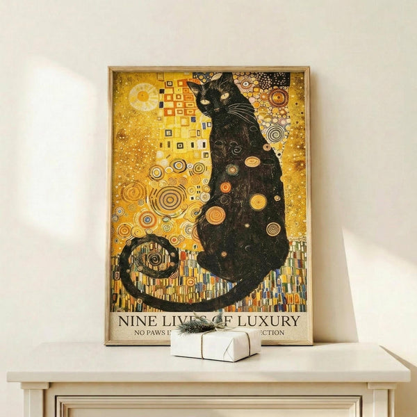 May include: Framed poster featuring a black cat in Gustav Klimt's ornate golden style with geometric patterns, circular motifs, and rich yellow background. The artwork shows intricate decorative elements and swirling designs characteristic of Art Nouveau. Small white gift box sits on light wood shelf below the natural wood-framed print against white wall.