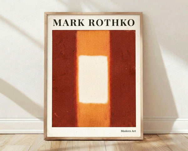 May include: Framed art print featuring abstract color field painting with warm orange and deep red rectangular forms surrounding a white central rectangle, displayed in light wood frame against white wall on wooden floor with natural lighting casting soft shadows