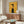 May include: Mid-century modern living room with vintage French advertising poster on wall featuring stylized woman in black beret and striped top on golden yellow background with "prestige" and "chic" text. Walnut credenza below, white sculptural chair, glass coffee table, and contemporary lighting fixtures complete the scene.